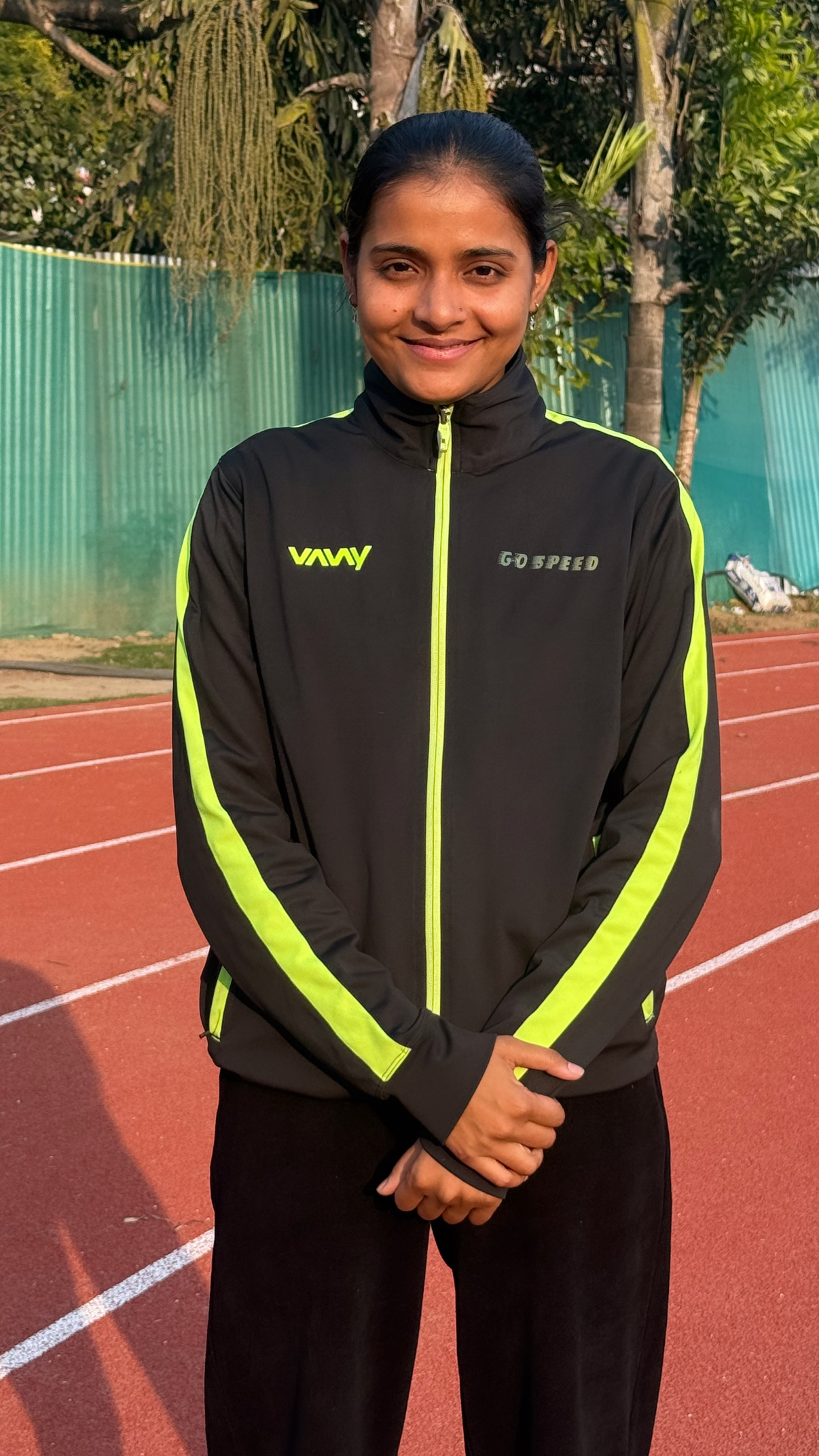 Coach Preeti in GO Speed Academy black and neon yellow track jacket on professional track