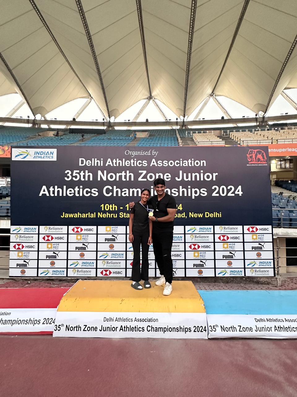 Medal ceremony with coach and young athletes at stadium
